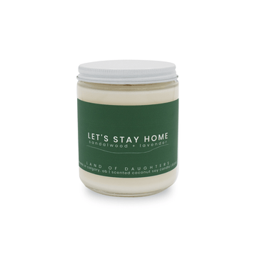 8oz Glass Jar candle with white lid and a dark green label that reads Let's Stay Home, sandalwood + lavender is photographed on a white background.