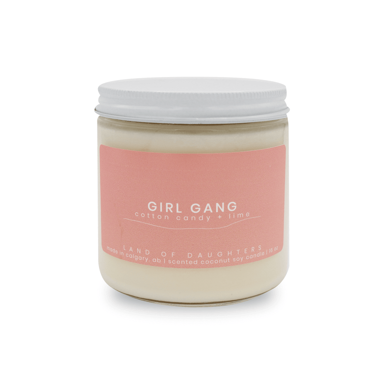 a 16oz glass jar candle with a white lid and a light pink label reading Girl Gang, cotton candy + lime on a white background.