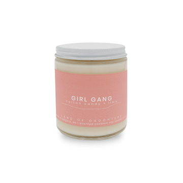 a 8oz glass jar candle with a white lid and a light pink label reading Girl Gang, cotton candy + lime on a white background.