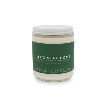 8oz Glass Jar candle with white lid and a dark green label that reads Let's Stay Home, sandalwood + lavender is photographed on a white background.